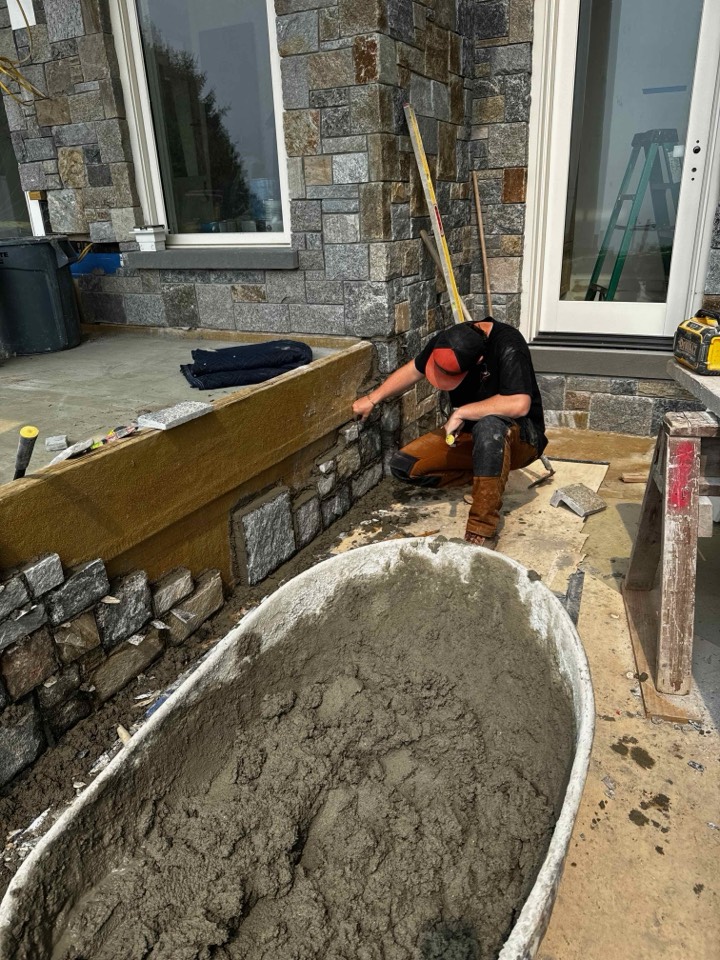 Foxpoint mason laying out veneer at a patio door