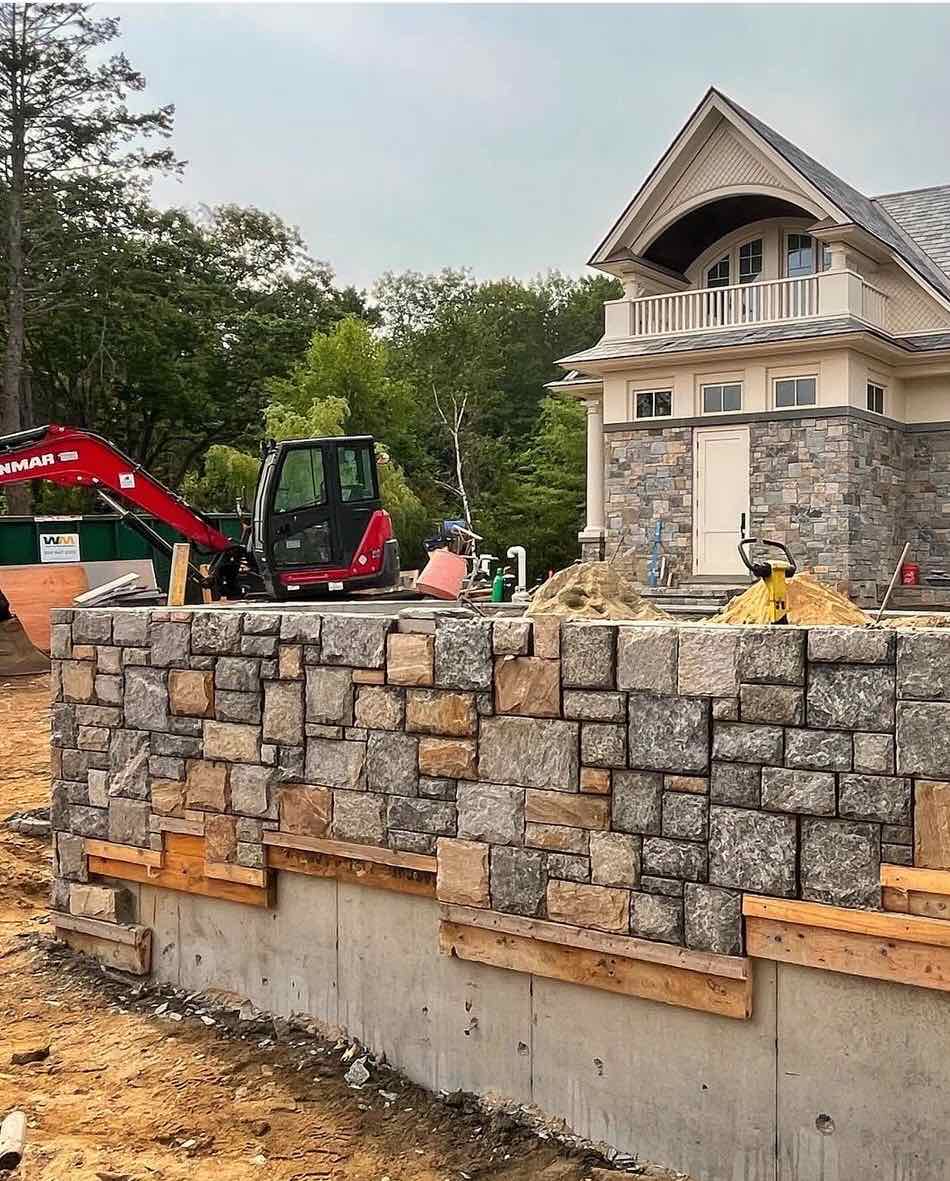 Stone knee wall and site grading in front of a coastal home